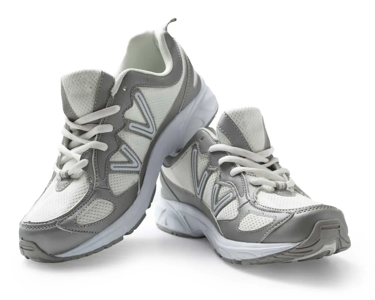 Zwei graue Laufschuhe mit weißer Sohle und weichem Schatten vor Weiß, freigestellt