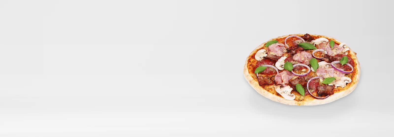 Belegte Pizza mit Salami, Schinken und Basilikum von schräg oben, freigestellt auf hellem Studiogrund