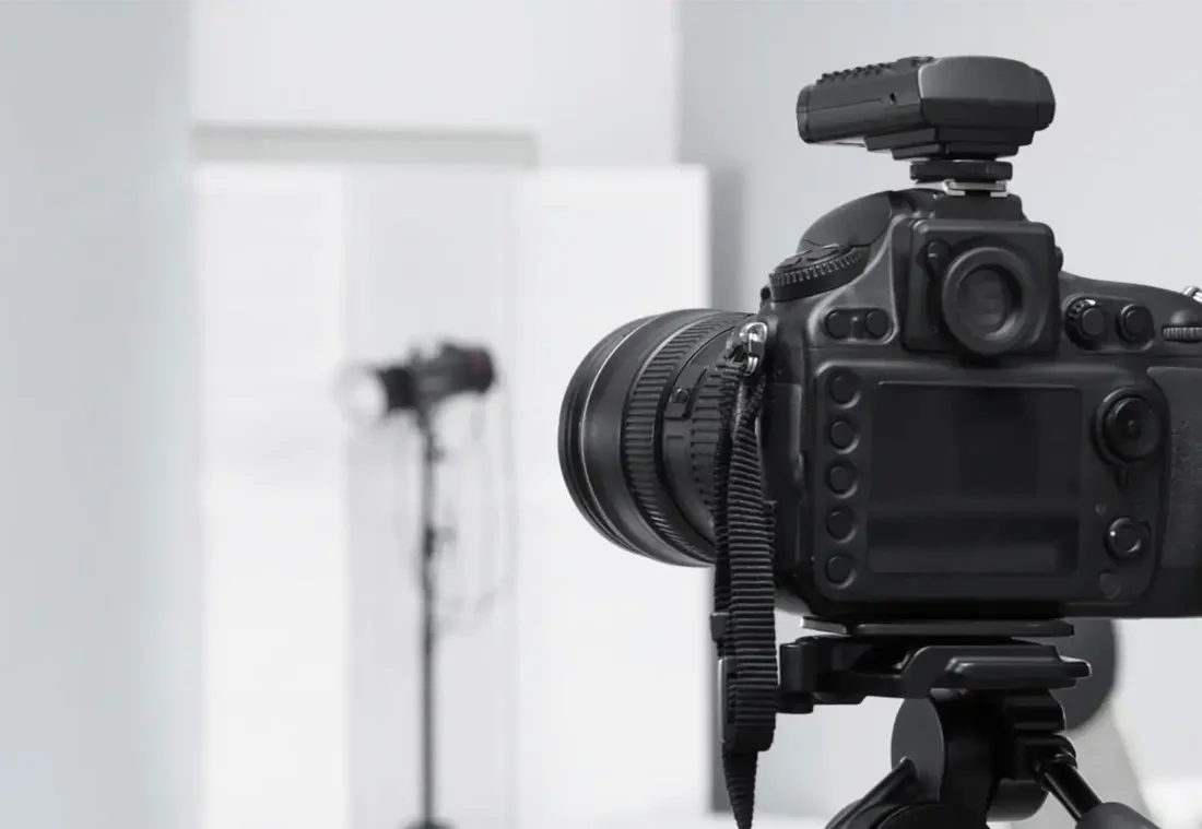 Spiegelreflexkamera auf Stativ vor Studioblitz mit Softbox, Blick ins Fotostudio